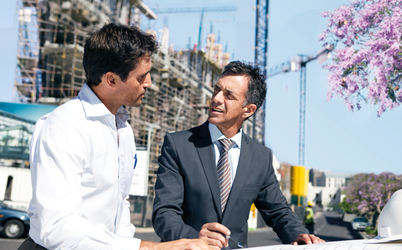Due uomini parlano davanti a un cantiere