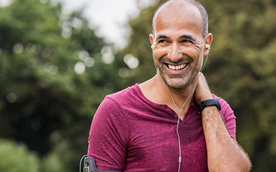 Mature man listening to music while resting after jogging